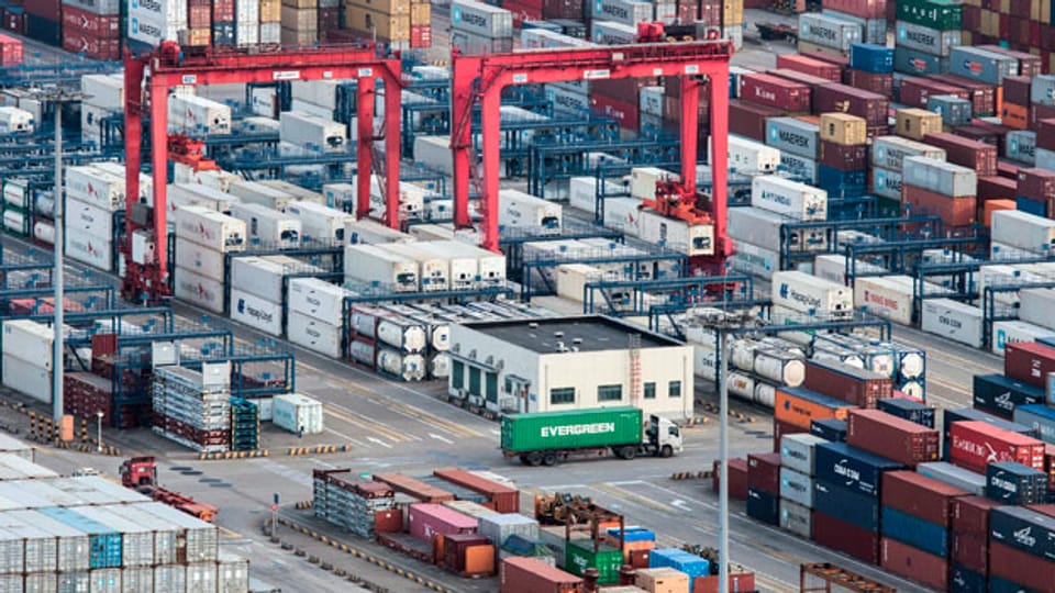 Lastwagen zwischen gestapelten Frachtcontainern im Yangshan-Hafen in Shanghai.