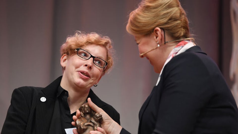 Die Autorin Manja Präkels (links) erhält von der Bundesministerin Franziska Giffey (SPD) die Momo-Trophäe auf der Frankfurter Buchmesse.