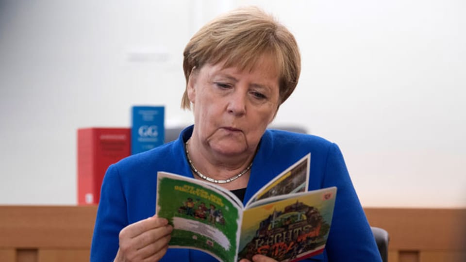 Bundeskanzlerin Angela Merkel mit der Broschüre «Fit für den Rechtsstaat - fit für Hessen».