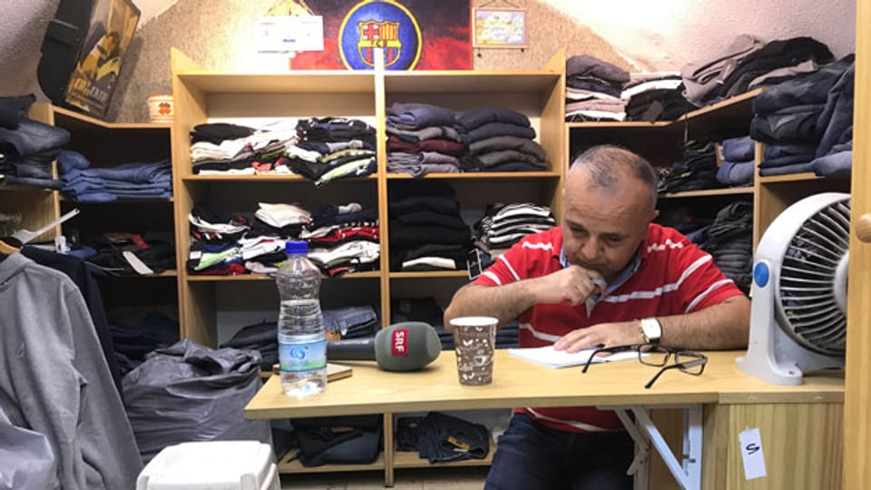 Khaled Essaheb sitzt in seinem winzigen Kleiderladen und wartet auf Kundschaft.