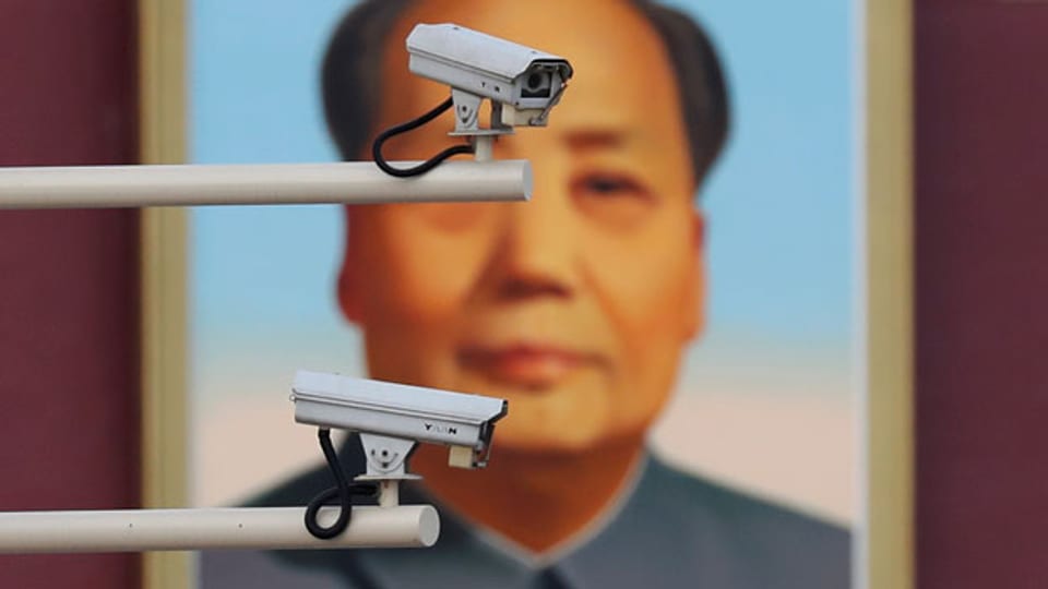 Überwachungskameras vor einem Porträt von Mao Zedong am Tiananmen-Tor in Peking.