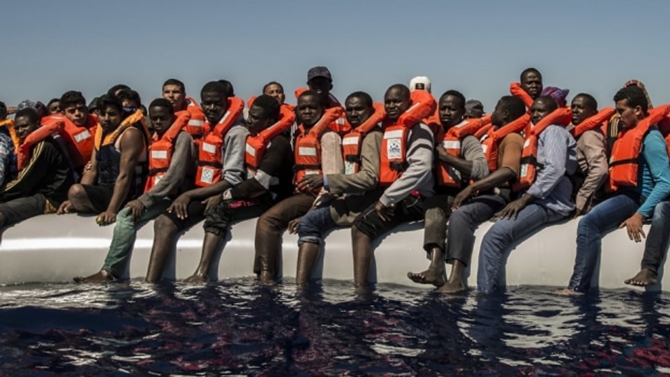 Flüchtlinge warten vor der Küste Lybiens auf Rettung.