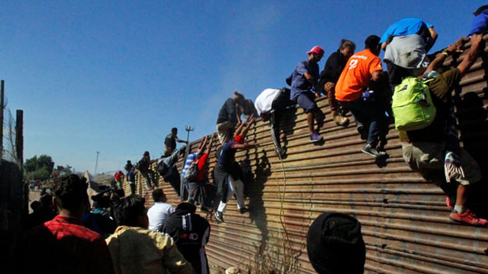 Migranten besteigen in Tijuana den Grenzzaun zwischen Mexiko und den USA.