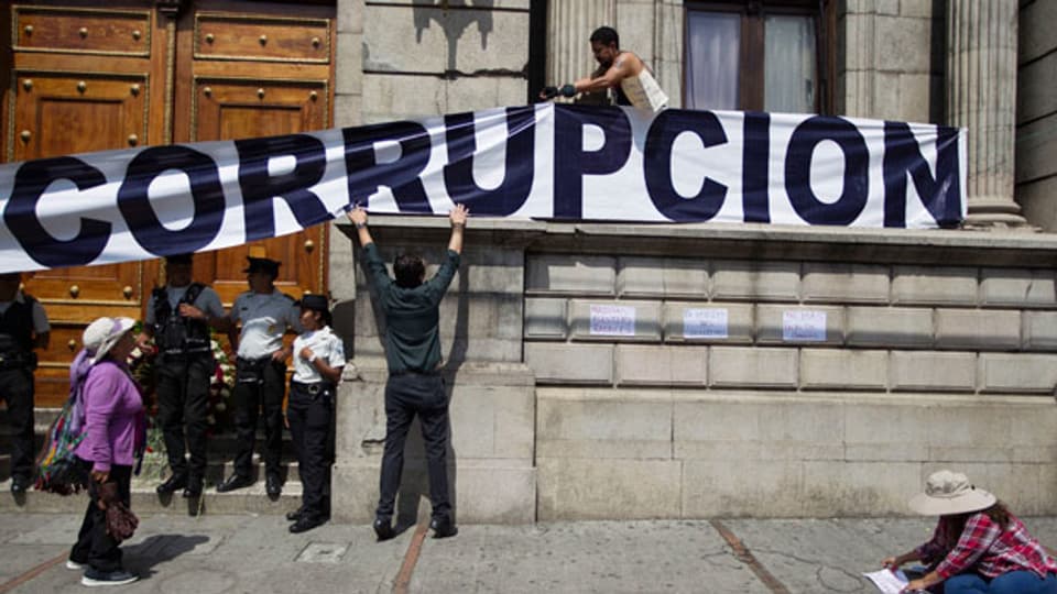 Demonstranten platzieren einen Banner an der Fassades des guatemalischen Kongresshauses.