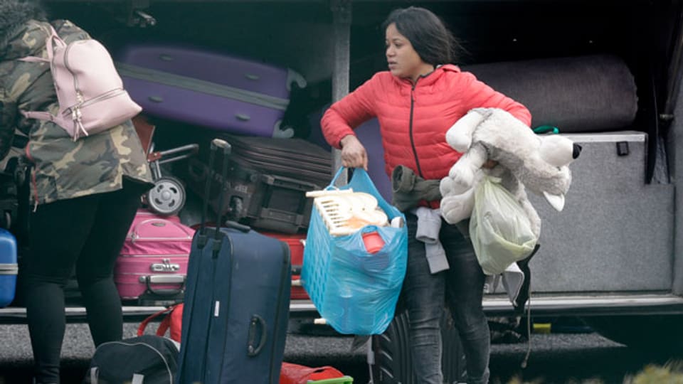 Migranten packen ihr Gepäck zusammen, um das Flüchtlinszentrum in Castelnuovo in Italien zu verlassen.