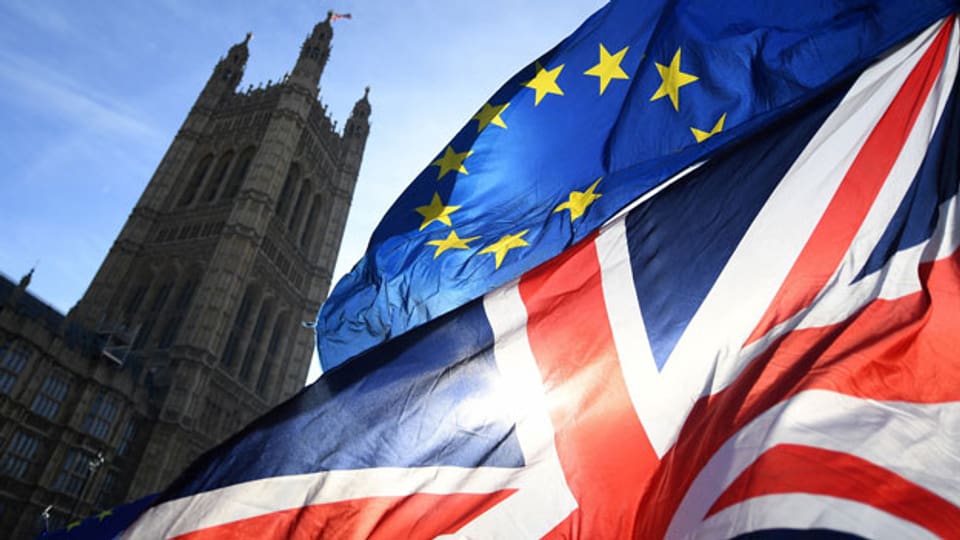 Fahnen der EU und Grossbritannien und im Hintergrund das Regierungsgebäude in London.