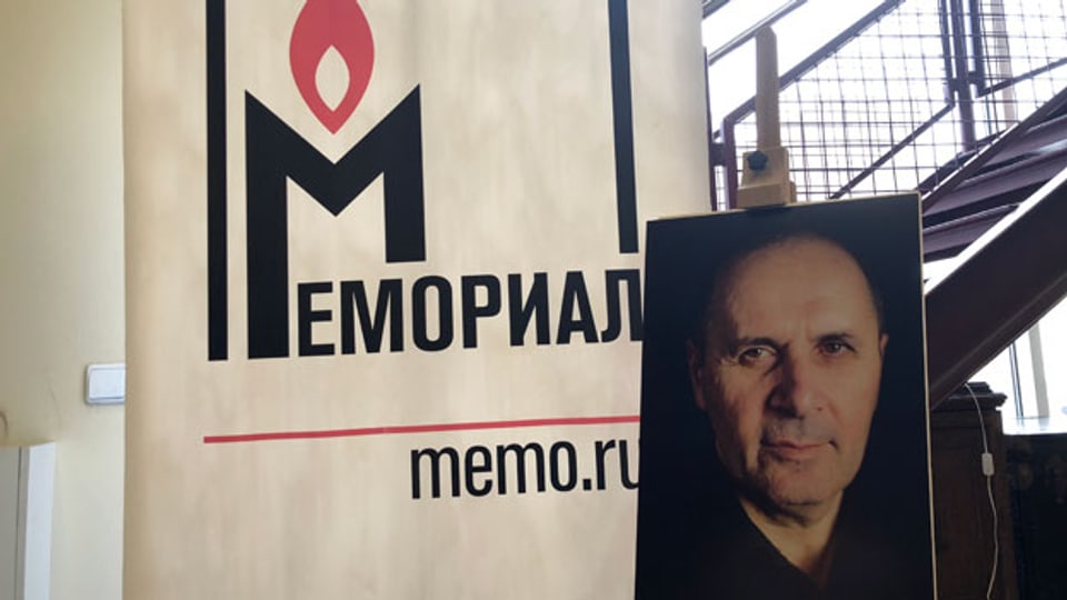 Das Portraitfoto von Oyub Titiev neben dem Memorial-Logo.