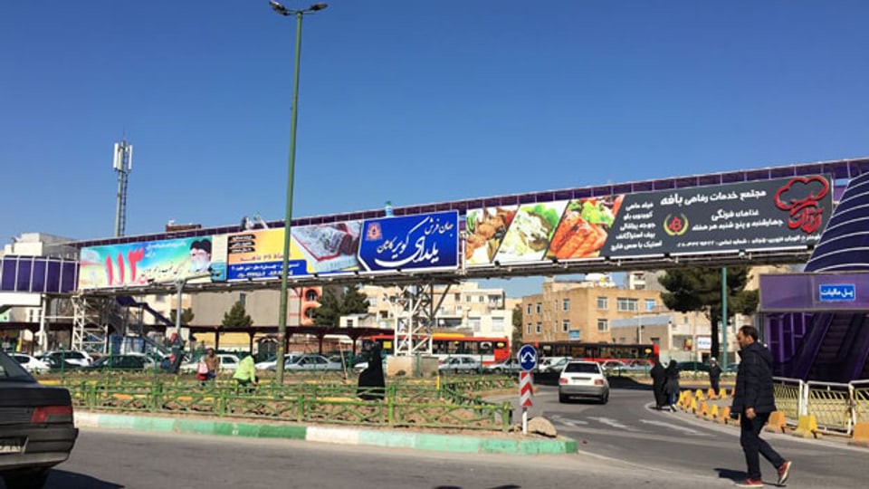 Strassenszene ausserhalb Teherans: Politische Botschaften neben Werbung für Teppiche und Cordon bleu vereint auf einer Plakatwand. Iran bleibt vielschichtig in seiner Krise.
