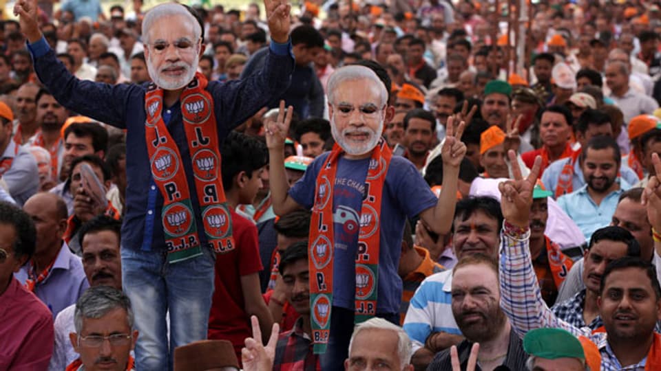 Inder, die Masken von Narendra Modi tragen, während des Wahlkampfs der Bharatiya Janata-Partei (BJP).