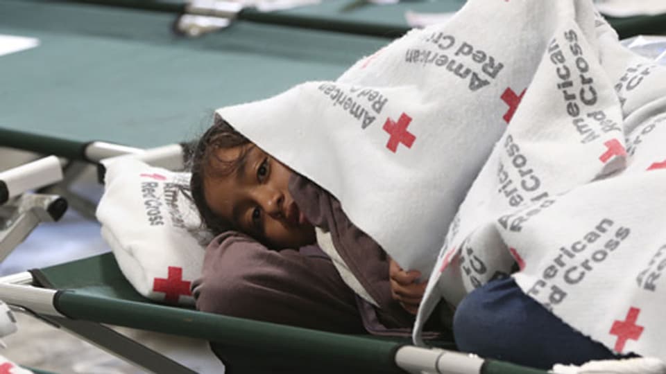 Ein junges Mädchen hält sich unter ihrer Decke warm in einer Flüchtlingsunterkunft in El Paso.