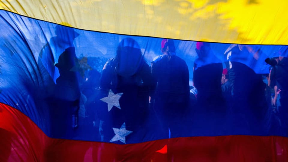 Anhänger von Juan Guaido vor der venezolanischen Flagge.