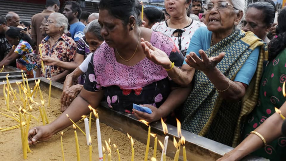 Nach den Anschlägen in Sri Lanka entzünden Passanten Kerzen für die Opfer.