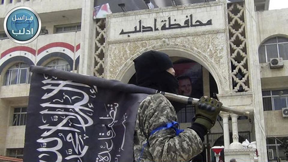 Ein Kämpfer der als-Qaida-verknüpften Nusra-Front vor dem Gouverneursgebäude in der Provinz Idlib, Nordsyrien.