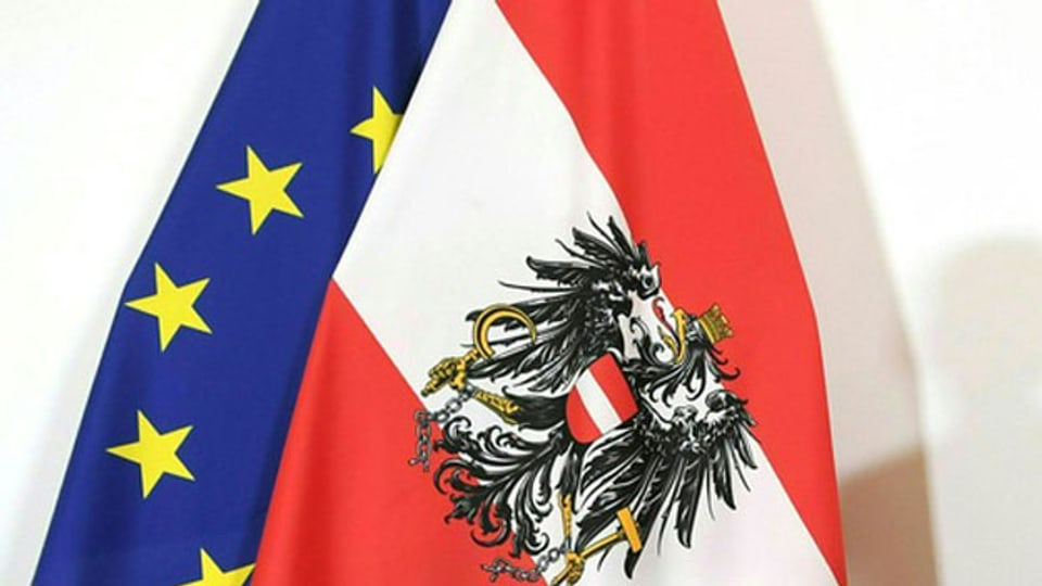Die Fahne von Österreich im Vordergrund und die Fahne der EU.