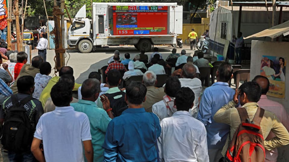 In Mumbai verfolgen Menschen die Wahlergebnisse auf einem Bildschirm.