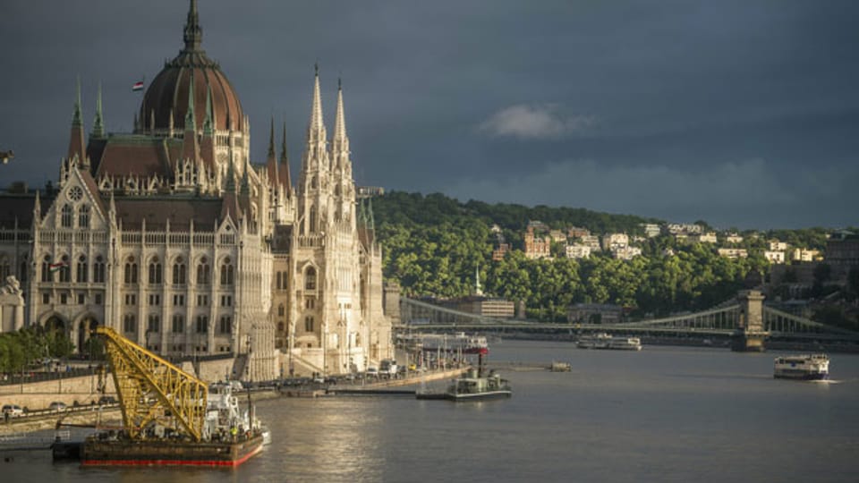 Ein Schiff mit Kran liegt vor dem Parlamentsgebäude, unweit der Unfallstelle in Budapest, Ungarn.