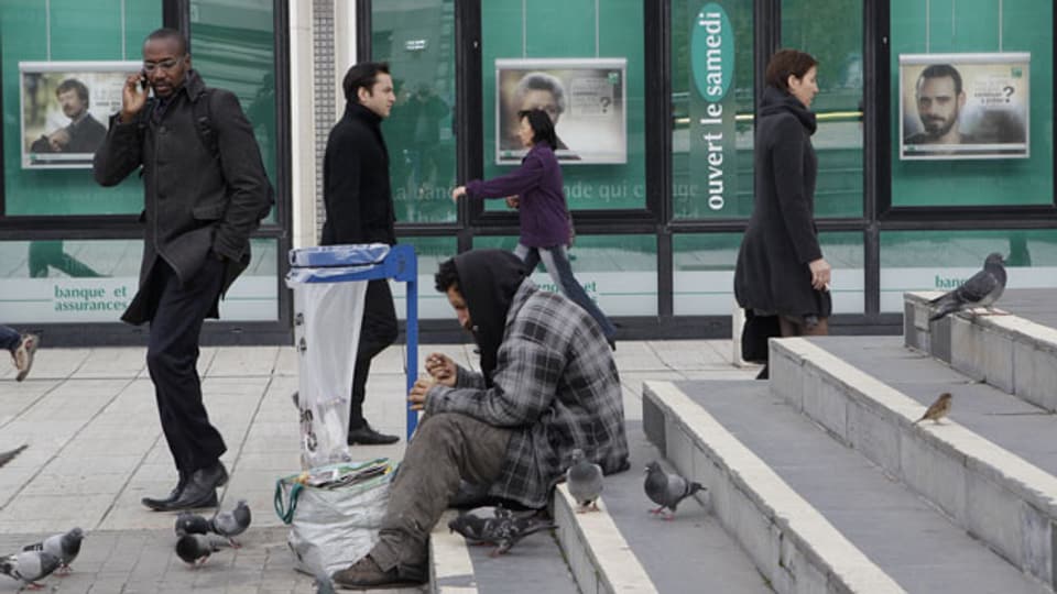Ein Obdachloser im Geschäftsviertel la Defense in Paris.