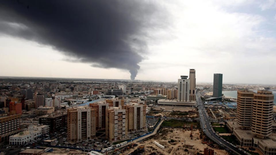 Symbolbild. Die Stadt Tripolis, im Hintergrund Rauch vom Flughafen.
