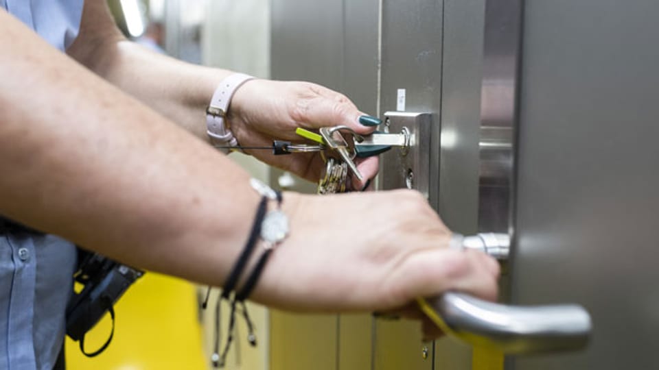 Eine Aufseherin öffnet eine Gefängniszelle im Gefängnis Limmattal.