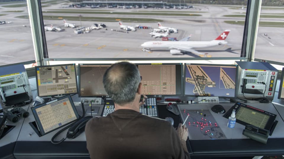 Ein Mitarbeiter von Skyguide kontrolliert die Monitore und hat Blick auf das Flugfeld, bei Skyguide im Tower des Flughafen Zürich Kloten.