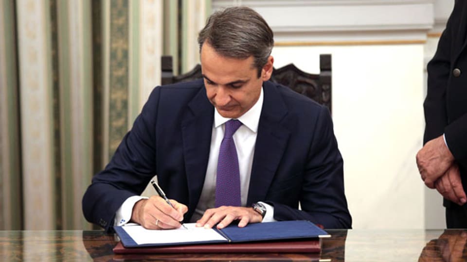 Kyriakos Mitsotakis unterzeichnet Dokumente nach seiner Vereidigung als neuer griechischer Premierminister.