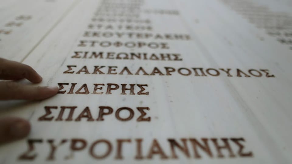 Ein Mann sucht nach Namen der Opfer des Massakers von Distomo in Griechenland, das die Nazis während des Zweiten Weltkriegs begangen haben.