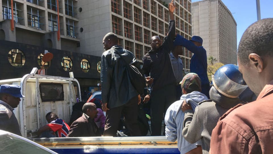 Männer werden in Harare (Simbabwe) verhaftet und auf einen Pickup verladen.