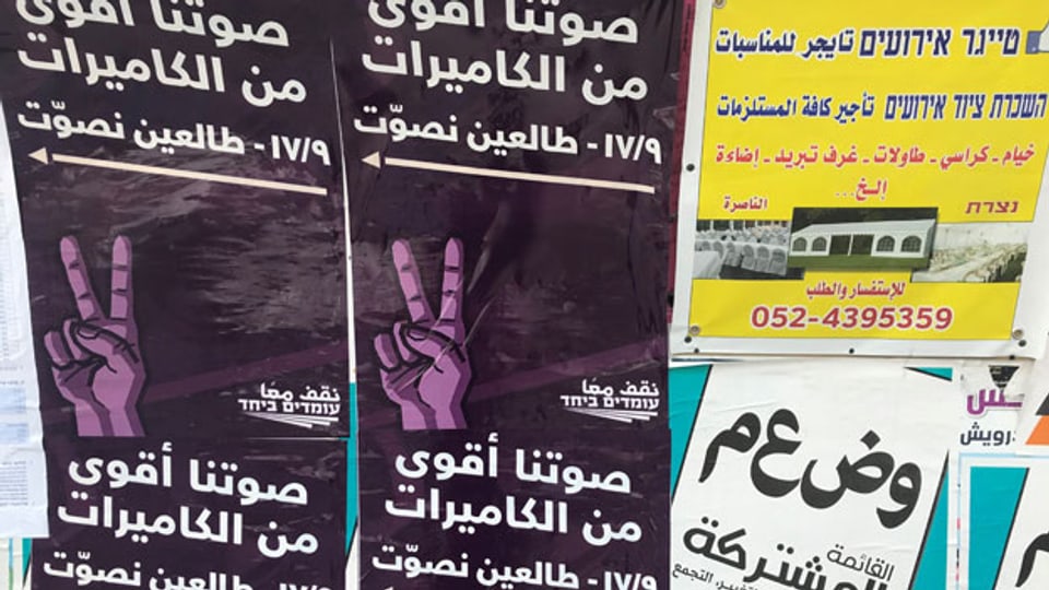 Plakatwand in Nazareth mit Victory Zeichen: «Unsere Stimmen sind stärker als eure Kameras». (Anspielung auf die Überwachungskameras in arabischen Wahllokalen).