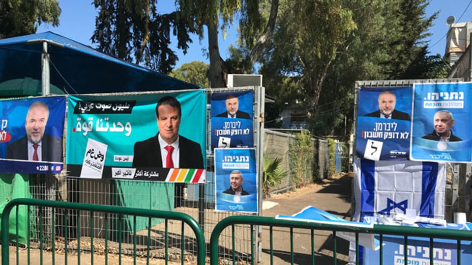 Vor dem Wahlbüro in Haifa hängen die Plakate der Kandidaten.