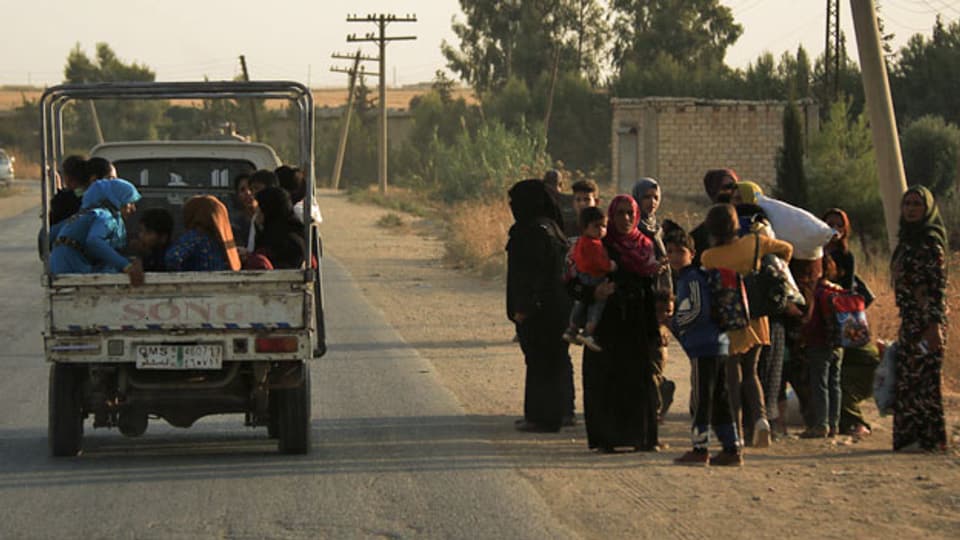 Syrer und Syrerinnen fliehen in Ras al Ayn im Nordosten Syriens vor türkischen Truppen.
