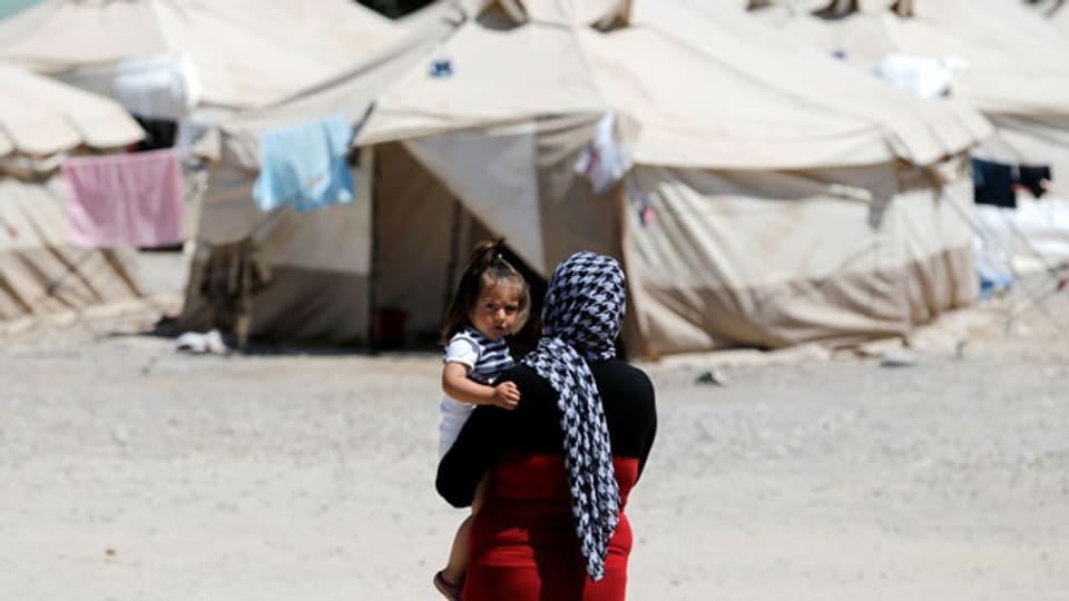 Eine Migrantin trägt ein Kind im Flüchtlingslager in Schisto bei Athen.