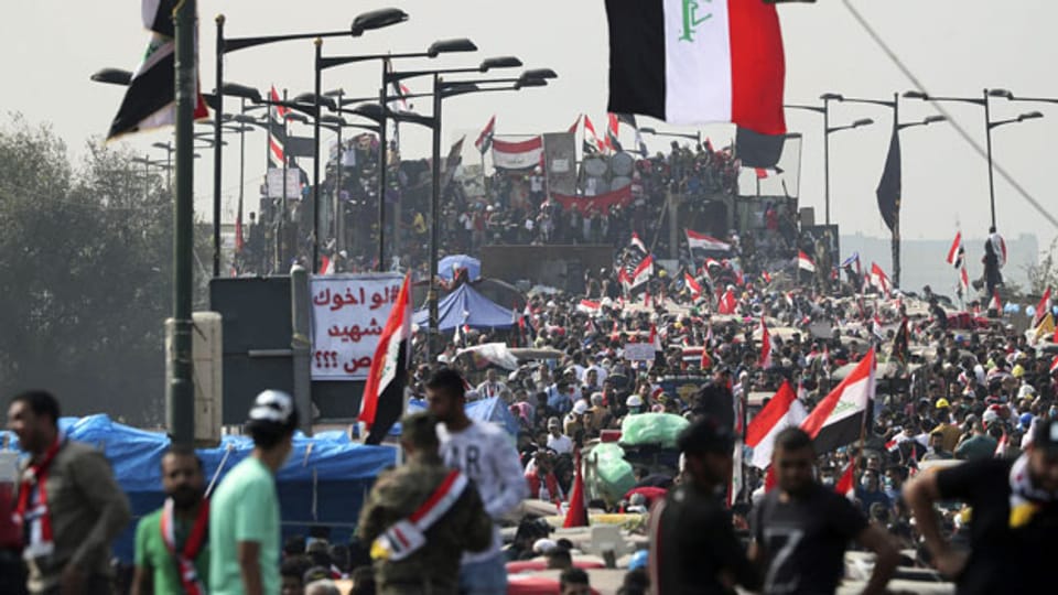 Anti-Regierungs-Demonstranten auf Barikaden, die von irakischen Sicherheitskräften errichtet wurden.