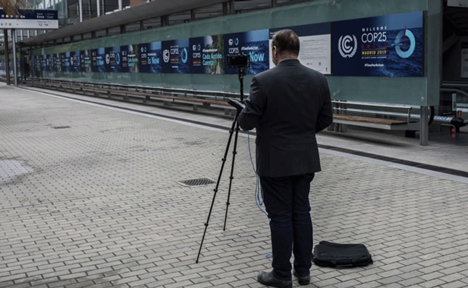 Ein Journalist vor dem Gebäude der Klimakonferenz