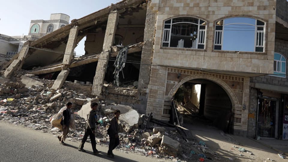 Einheimische Jungen passieren zerstörtes Gebäude in Sanaa, Jemen, am 16. Januar 2020.