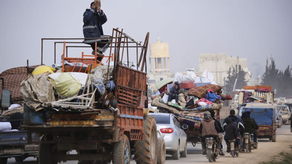 Syrische Flüchtlinge verlassen die Stadt Hazano in Richtung Idlib.