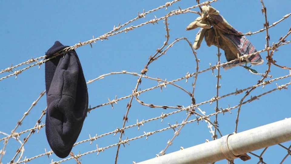 Eine Kappe und Handschuh am Grenzzaun zwischen Spanien und Marokko in der spanischen Enklave Melilla.