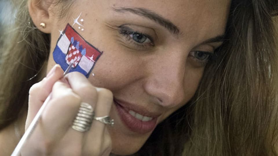 Junge Kroatin mit Flagge auf der Backe.