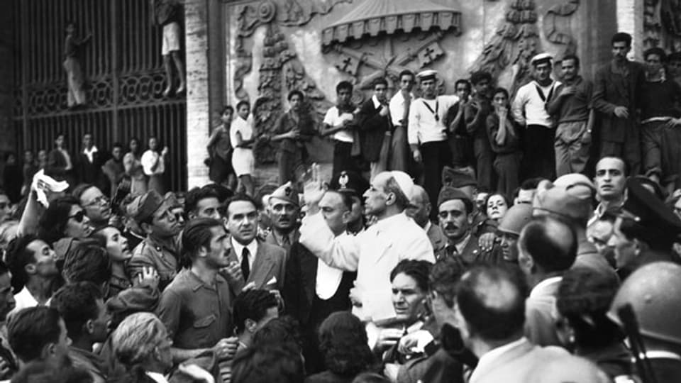 Papst Pius XII besichtigt nach einer Bombardierung Roms durch die Alliierten im Zweiten Weltkrieg den Schaden.