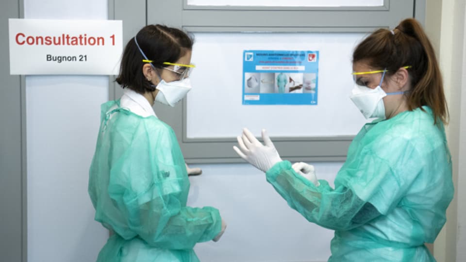 Zwei Mitarbeiterinnen des Universitätsspitals Lausanne rüsten sich für das Corona-Virus.