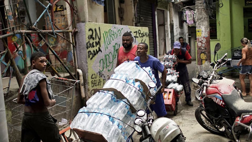 Männer bringen Wasser und Soda in den Slum Rocinha in Rio de Janeiro, Brasilien.