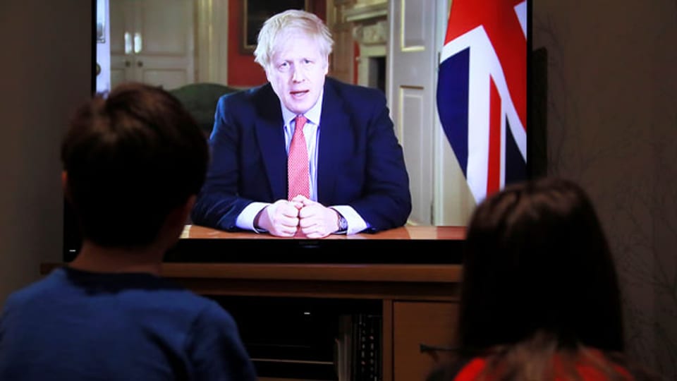 Zwei Kinder verfolgen die Pressekonferenz des britischen Premierministers Boris Johnson.