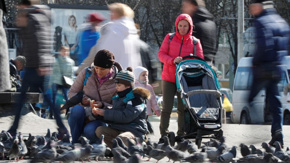 Menschen füttern Tauben in Minsk- trotz wachsender Besorgnis über die Ausbreitung des Coronavirus