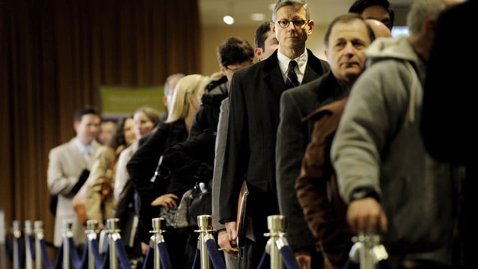 Jobsuchende Amerikaner stehen in einer Warteschlange vor einem Arbeitsamt.