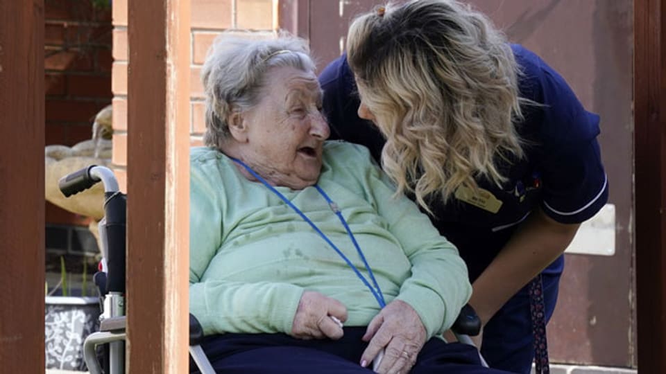 Eine Pflegerin betreut eine Bewohnerin eines Altersheims in Grossbritannien.