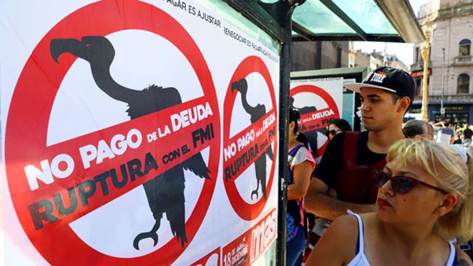 Buenos Aires: Fussgänger gehen an Plakaten vorbei, auf denen «Nein zur Bezahlung der Schulden» und «Bruch mit dem IWF».