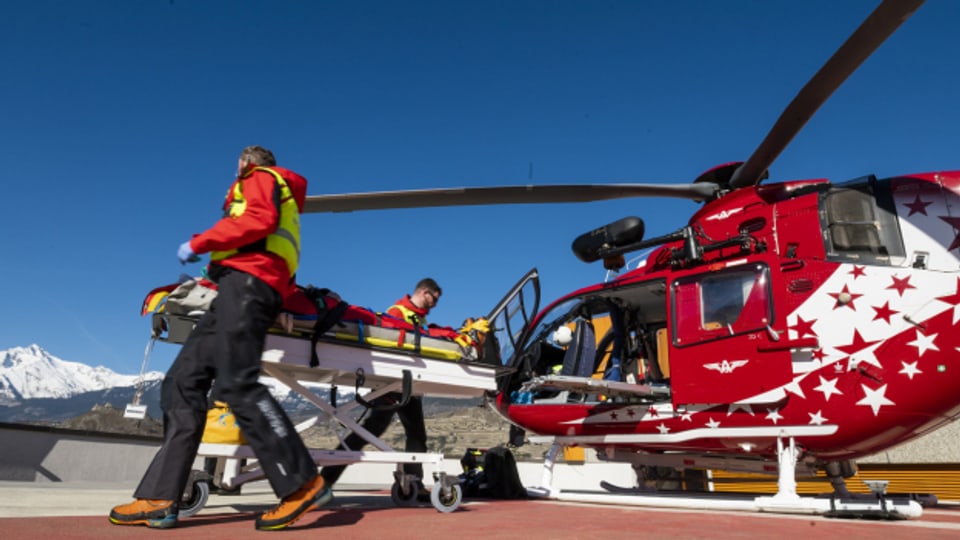 Rettungskräfte der Walliser Fluggesellschaft Air Glaciers bergen einen verletzten Skifahrer.