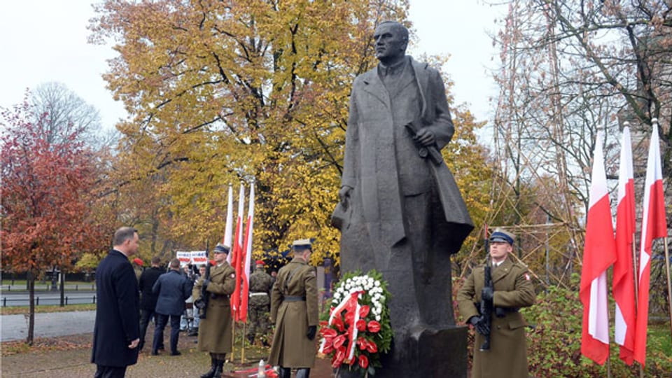 Polens Präsident Andrzej Duda steht vor dem Monument von Roman Dmowski in Warschau.