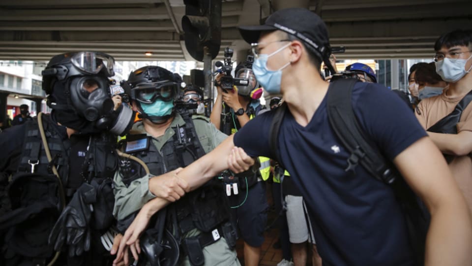 Bereitschaftspolizisten verhaften einen Demonstranten.
