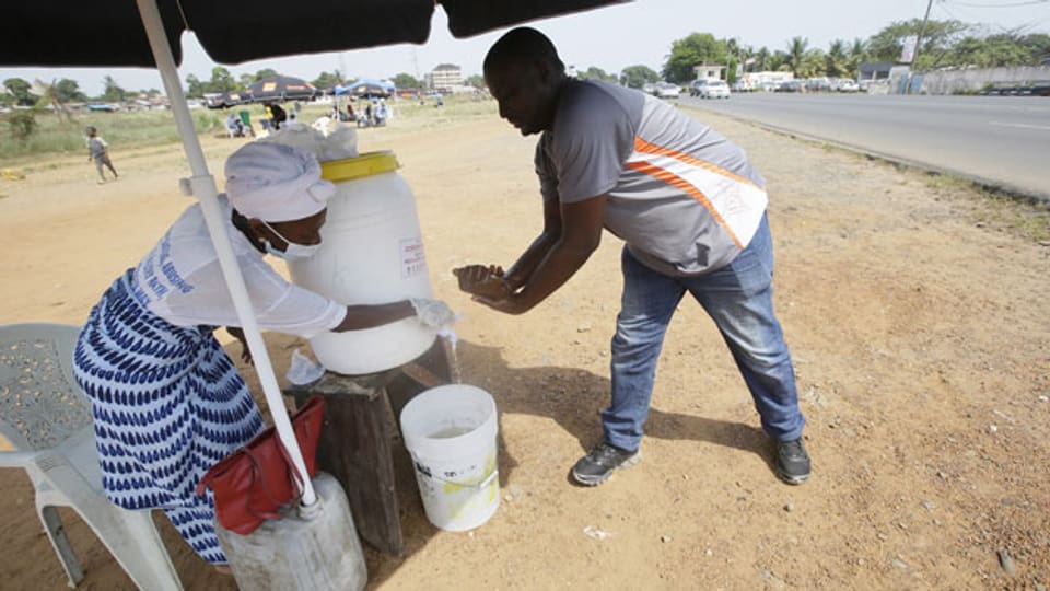Ein Mann desinfiziert seine Hände in Monrovia, Liberia.