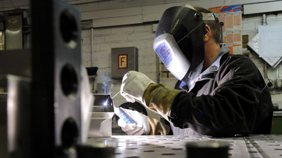 Ein Mitarbeiter eines metallverarbeitenden Betriebes beim Schweissen.